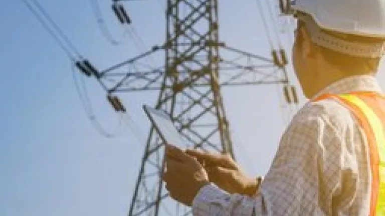 Electrical engineer with tablet inspecting electrical tower.jpg
