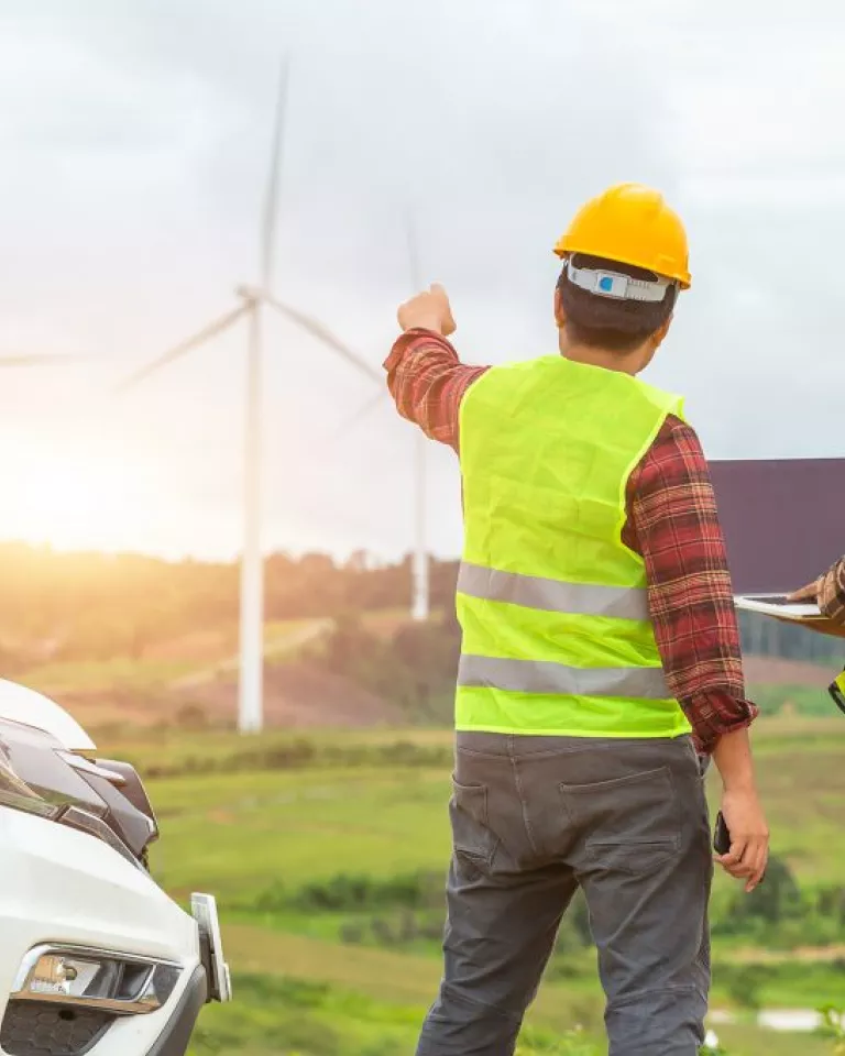 men pointing at windmill