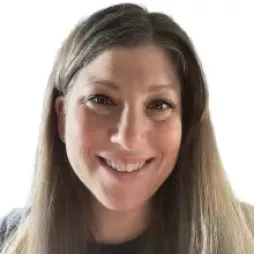 Smiling person with long brown hair against a white background.