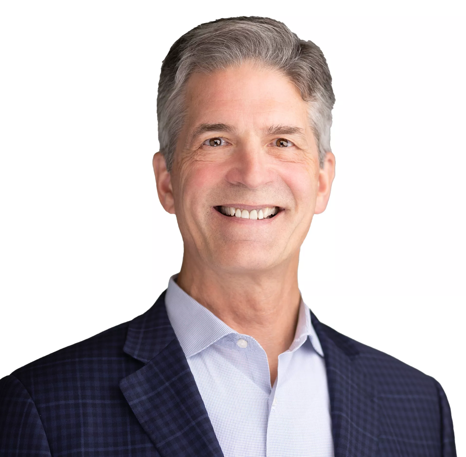 A man with gray hair smiling, wearing a dark checkered blazer and a light blue shirt, against a white background.