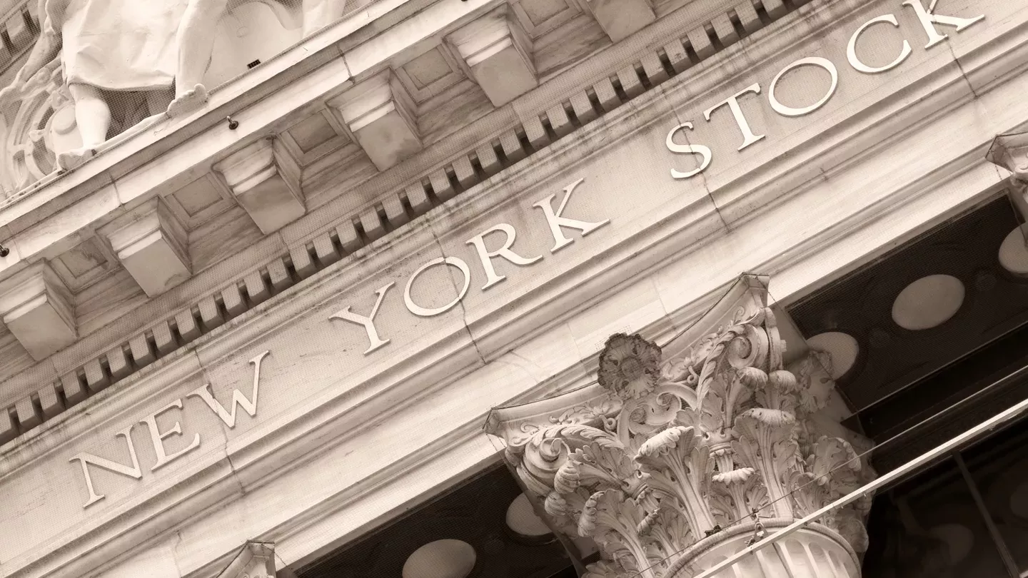 Sepia-toned close-up of the New York Stock Exchange building, showing ornate Corinthian columns and the words 'New York Stock' engraved on the facade.